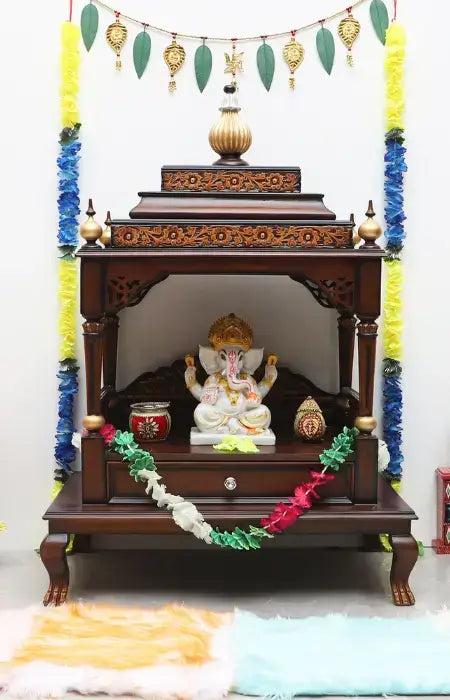 pooja items kept in a wooden pooja mandir at home